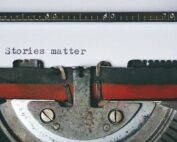Close up photo of paper and typewriter with the typed phrase Stories Matter, taken by Suzy Hazelwood